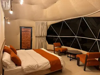 a bedroom with a large bed and a table and chairs at Rum Horizon Camp& Tours in Wadi Rum