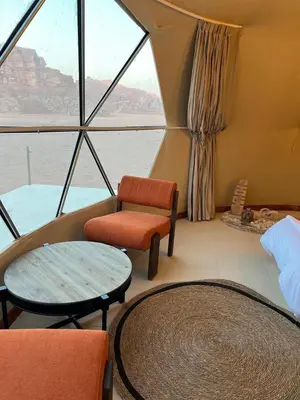 a room with a bed and a table and chairs at Rum Horizon Camp& Tours in Wadi Rum