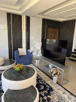a living room with a table and a television at Sports city 2bd room in Amman