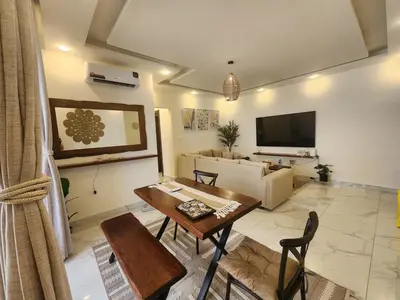 a living room with a table and a couch at Cozy Appartment In Shmessani in Amman