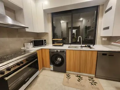 a kitchen with a washing machine and a sink at Cozy Appartment In Shmessani in Amman