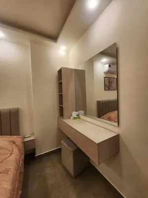 a bathroom with a vanity with a mirror and a bed at Cozy Appartment In Shmessani in Amman