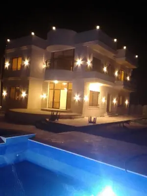 a large house at night with a swimming pool at Rest Sea Chalet shearing Room one bed