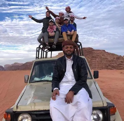 a group of people sitting on the back of a truck at Wadi Rum Bubble Dream in Wadi Rum