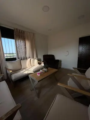 a living room with a couch and a table at Pine Country Farm Stay in Umm al Manābī‘