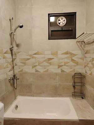a bath tub in a bathroom with a window at Pine Country Farm Stay in Umm al Manābī‘