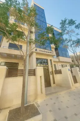 a building with a tree in front of it at Central Amman Twin Towers Apartment 2 in Amman