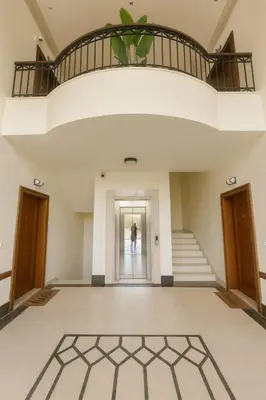 a large room with a staircase and a person in the distance at Prime City Luxury Apartment in Amman