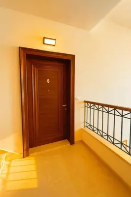 a hallway with a wooden door in a building at Prime City Luxury Apartment in Amman