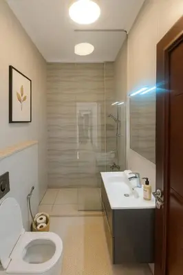 a bathroom with a toilet and a sink and a shower at Prime City Luxury Apartment in Amman