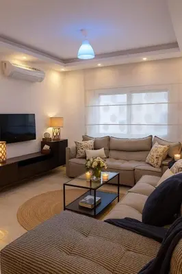 a living room with a couch and a tv at Elite Apartment Compound in Amman