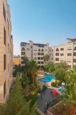 a view of a resort with a pool and buildings at Elite Apartment Compound in Amman