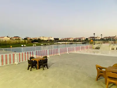 a patio with tables and chairs next to a body of water at Furnished Villa in Andalusian Compound for Rent in Madaba