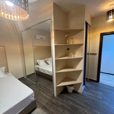 a small bedroom with a bed and a mirror at عبدون الشمالي -بالقرب من السفارة البريطانية in Amman