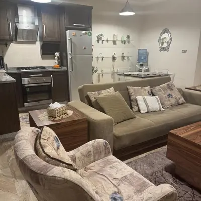 a living room with a couch and a kitchen at عبدون الشمالي -بالقرب من السفارة البريطانية in Amman