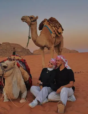 two men sitting in the desert with a camel at BUBBLE lUXURY RUM JNOPE CAMP in Wadi Rum