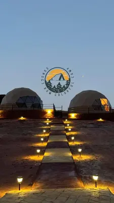 a group of three domes with lights in a field at WADI RUM BUBBlE AOSE CAMP in Wadi Rum