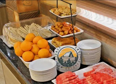 a buffet with plates of food and fruit on a counter at WADI RUM BUBBlE AOSE CAMP in Wadi Rum