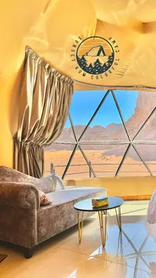 a living room with a couch and a view of the desert at WADI RUM BUBBlE AOSE CAMP in Wadi Rum