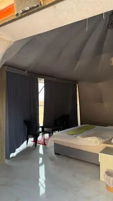 a bedroom with a bed and chairs in a tent at RUM NADINE LUXURY CAMP & Bubbles Hotel in Wadi Rum
