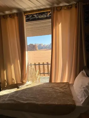 a bedroom with a bed and a window with a view at Desert soul in Wadi Rum