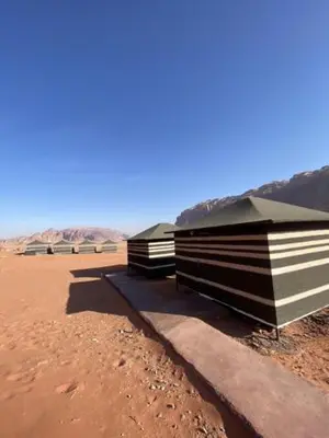 two buildings sitting on the sand in the desert at Wadi Rum Nights Tents in Wadi Rum