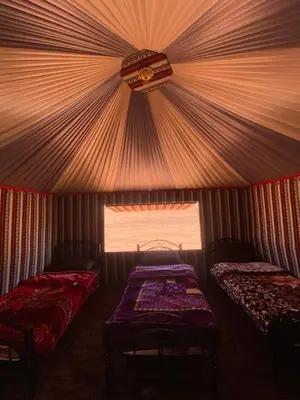 a room with two beds and a window at Wadi Rum Nights Tents in Wadi Rum