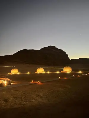 a group of tents in the desert at night at Sunrise Echo Camp in Wadi Rum