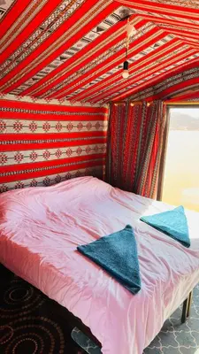 a bed with two towels on top of it at Desert Nights camp in Wadi Rum