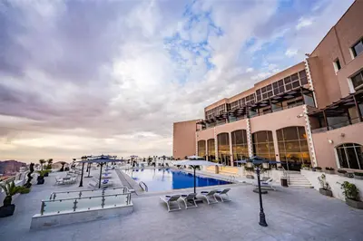 a courtyard with a pool and chairs and buildings at Petra Pillars Luxury Hotel in Petra
