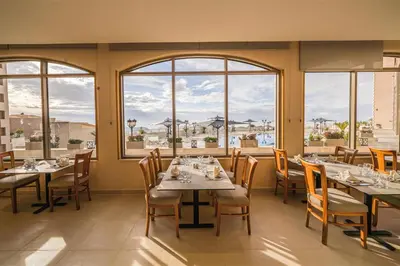 a restaurant with tables and chairs and windows at Petra Pillars Luxury Hotel in Petra