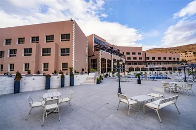 a courtyard with tables and chairs in front of a building at Petra Pillars Luxury Hotel in Petra