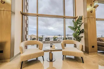 two chairs and a table in a room with a large window at Petra Pillars Luxury Hotel in Petra