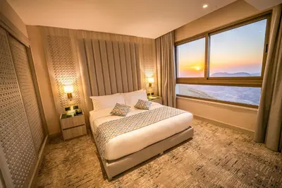 a bedroom with a bed and a large window at Petra Pillars Luxury Hotel in Petra