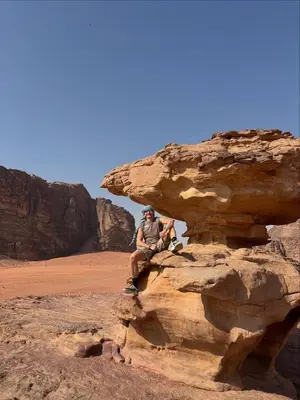two people sitting on a rock in the desert at ELENA lUXURY CAMP in Wadi Rum