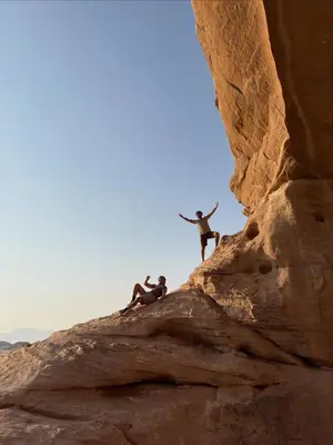 a group of people jumping off of a rock at ELENA lUXURY CAMP in Wadi Rum