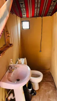 a small bathroom with a sink and a toilet at Desert Nights camp in Aqaba