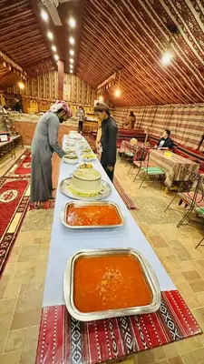 a long table with many plates of food on it at Desert Nights camp in Aqaba