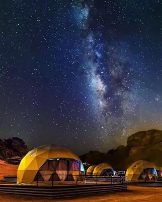 a group of tents under a starry sky at عماد رم in Wadi Rum