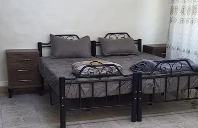 a bedroom with a black bed with a dresser at small house in Amman