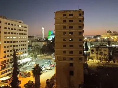 a tall building in a city at night at small house in Amman
