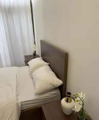 a bedroom with a bed and a vase on a table at شقة lvaisa الفندقيه in Umm Uthainah