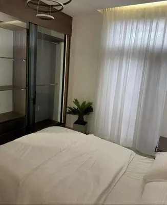 a bedroom with a large white bed and a window at شقة lvaisa الفندقيه in Umm Uthainah