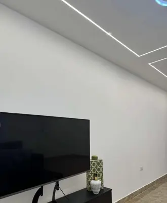 a large flat screen tv on a white wall at شقة lvaisa الفندقيه in Umm Uthainah