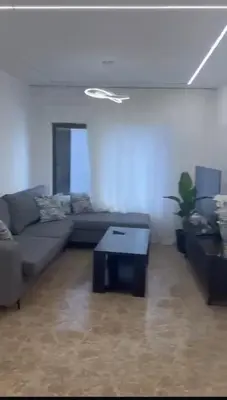 a living room with a couch and a table at شقة lvaisa الفندقيه in Umm Uthainah