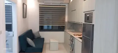 a small kitchen with a blue couch in a room at غزو 15 in Aydūn