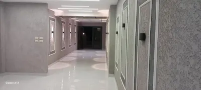 a hallway in a building with white floors and walls at غزو 15 in Aydūn
