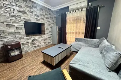 a living room with a couch and a flat screen tv at Central Budget Stay in Amman
