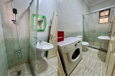 a bathroom with a washing machine and a sink at Central Budget Stay in Amman