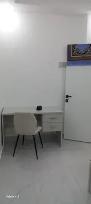 an office with a desk and a chair and a refrigerator at غزو 15 in Aydūn
